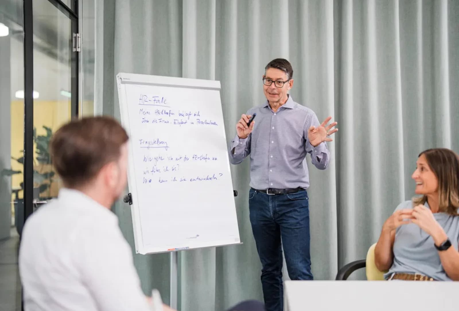 Hubert Lechner erklärt am Flipchart einen Führungsfall vor einer Gruppe von Teilnehmenden